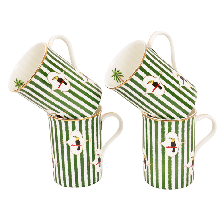 Set of four Toucan Tango mugs in green and white striped design with gold rim, two mugs tilted on top of two upright mugs, featuring a toucan bird motif and palm leaf accent inside the rim